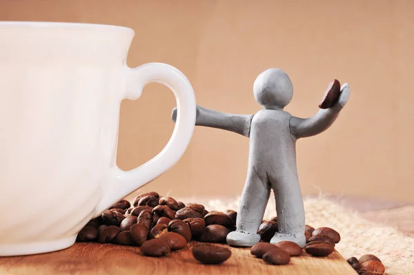 Plasticine man holding coffee bean — Stock Photo, Image