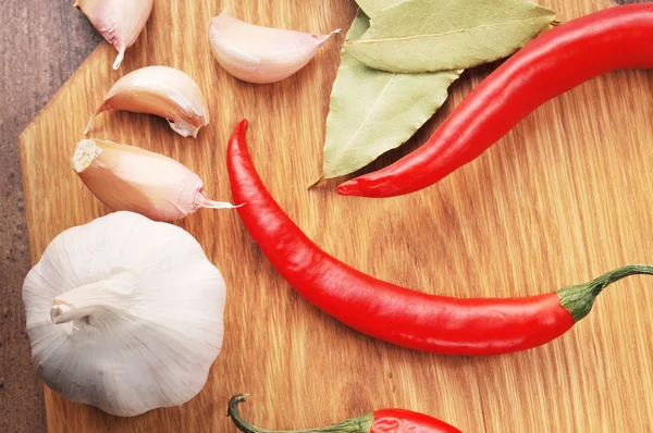 Chiles picantes con hojas de laurel, ajo entero y clavo de olor en un —  Fotos de Stock