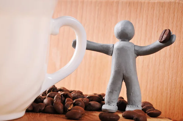 Plasticine hombre sosteniendo grano de café — Foto de Stock