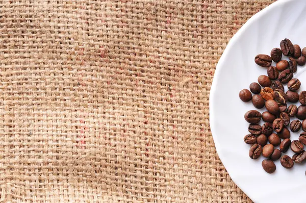 Grains de café sur une soucoupe en céramique — Photo