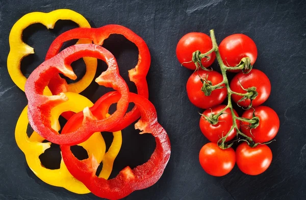 Świeże Pomidory Gałęzi Czerwonej Żółtej Papryki Plasterkami Ciemnym Tle — Zdjęcie stockowe