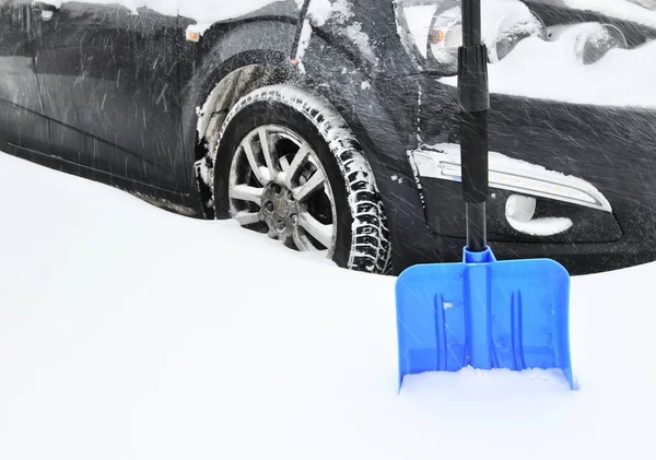 黑色汽车在密集的降雪下卡在雪堆和蓝色铲 — 图库照片