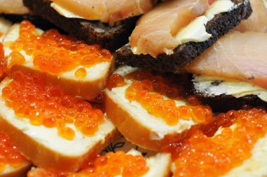 Tereyağı, siyah ve beyaz ekmek, kırmızı havyar ve somon sandviç Close-Up