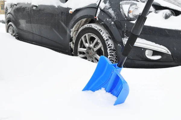 Pala Blu Nella Neve Contro Auto Nera Sul Parcheggio — Foto Stock