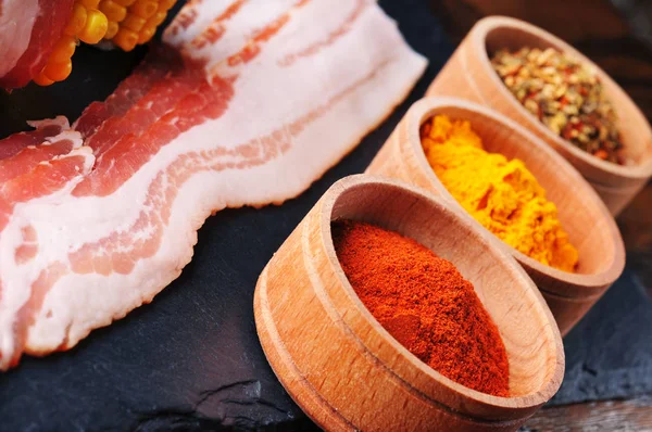 Raw Bacon Slices Bowls Different Dry Spices Slate Slab — Stock Photo, Image