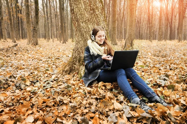 Красивая Молодая Девушка Наушниками Работает Черном Ноутбуке Парке Опавшими Листьями — стоковое фото