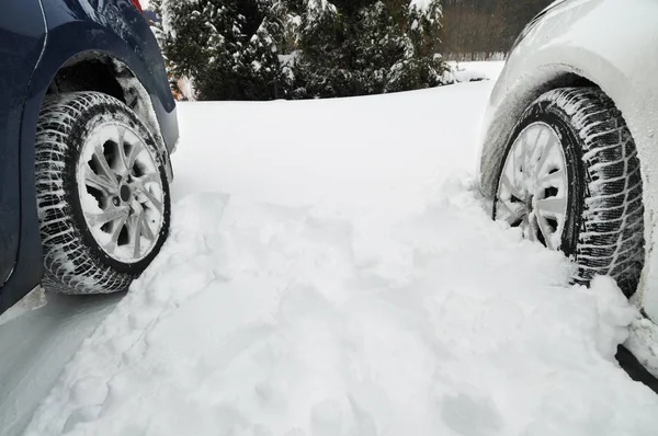 森も雪で冬用タイヤ 台青と白の車のクローズ アップ — ストック写真