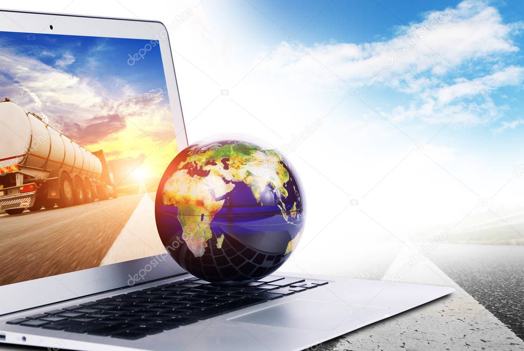 World globe on the silver laptop with truck on screen isolated on white background