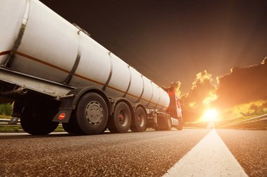 Büyük metal yakıt tanker kamyon yakıt karanlık gökyüzü günbatımı ile karşı nakliye