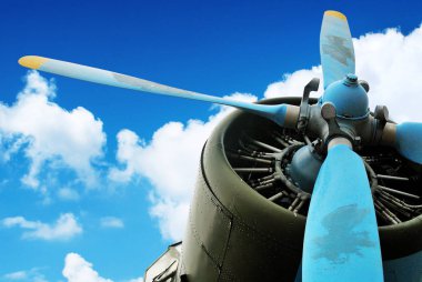 Bulutlar ile mavi gökyüzü mavi ve sarı pervane ile eski yeşil uçak motoru