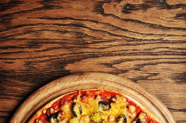 ラウンド ボード上の暗い背景の木おいしいイタリアンピザのトップ ビュー — ストック写真