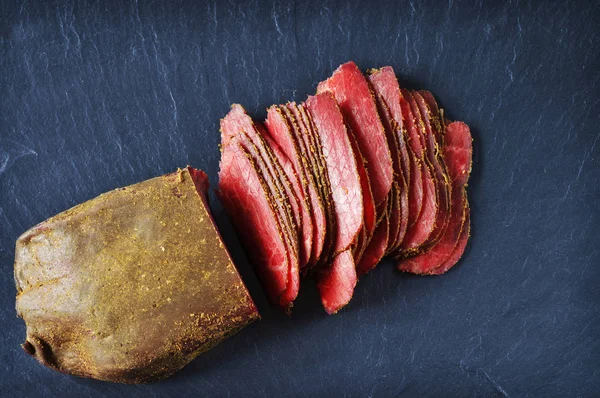 Φέτες Παστό Κρέας Κόκκινο Σκούρο Μπλε Φόντο — Φωτογραφία Αρχείου