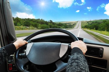 Mavi gökyüzü güneş ile karşı hareket de kırsal yol direksiyon simidi sürücünün el ile kamyon aracınıza