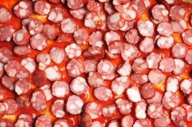 Pizza hamur üzerinde kırmızı ketçap soslu sosis dilimleri Close-Up