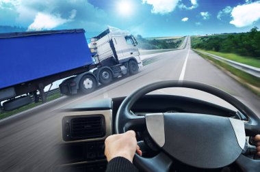 Abstract background with truck with trailer, truck steering wheel and road against sky