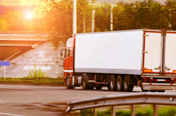 Vrachtwagen met een aanhangwagen rijdt snel op het platteland weg tegen — Stockfoto