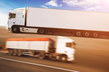 Hareket halindeki kamyon ve römorklu soyut kavram arka planı ve turuncu ışıklı mavi gökyüzü