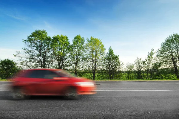 Carro Hatchback Vermelho Dirigindo Rápido Estrada Rural Com Árvores Verdes — Fotografia de Stock