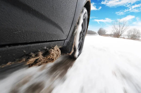 Detailní Záběr Černé Auto Jedoucí Rychle Sněhu Silnice Proti Modré — Stock fotografie
