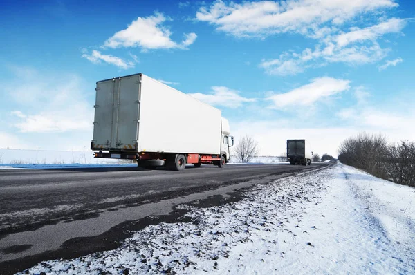 Dwie Białe Ciężarówki Miejscem Tekst Wsi Zimowa Droga Śniegiem Tle — Zdjęcie stockowe