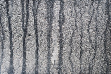 Kapalı yollarda çamurla kaplı siyah araba penceresi.