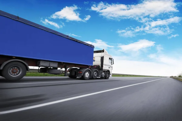 一辆白色的大卡车和一辆蓝色的拖车 上面有文字的空间 在乡间道路上 在蓝天和云彩的映衬下行驶着 — 图库照片