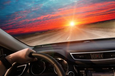Gün batımında otoyolda, gösterge paneliyle arabanın içinden bak.