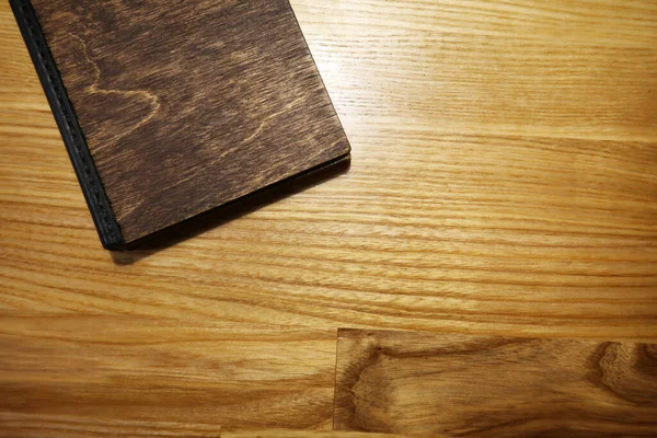 木製背景の閉じたノートブックのトップビュー — ストック写真