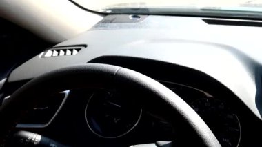 Adam arabanın direksiyonunu çeviriyor.