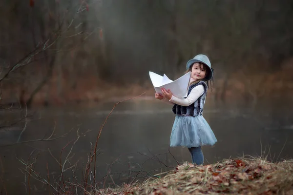 Menina com grande barco de papel — Fotografia de Stock