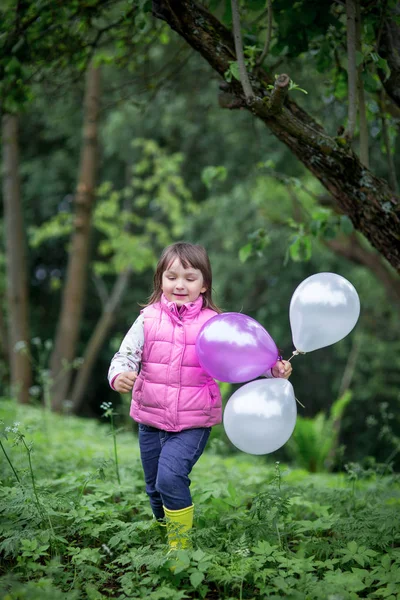 Flicka kör med ballonger — Stockfoto