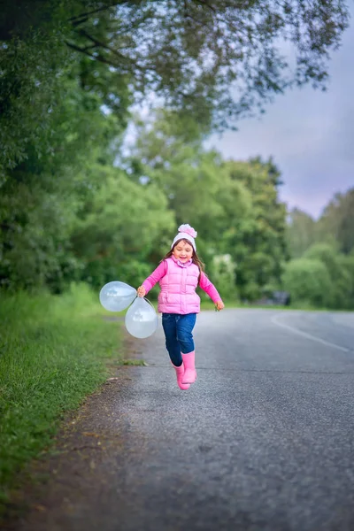 Flicka kör med ballonger — Stockfoto