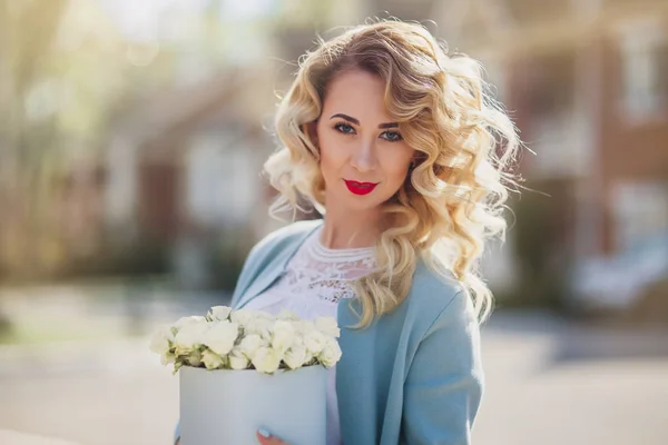 Mooie vrouw met papier doos met bloemen — Stockfoto