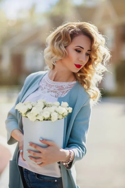Красивая женщина с бумажной коробкой цветов — стоковое фото