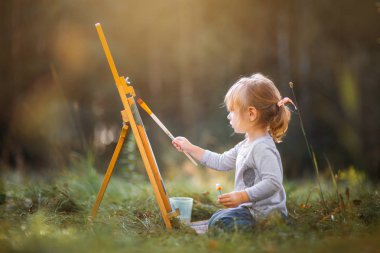 Little girl painting outdoors  clipart