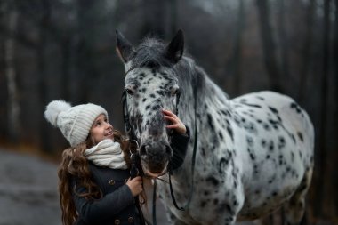 Genç kız portre Appaloosa at ve Dalmaçyalı köpekler ile 
