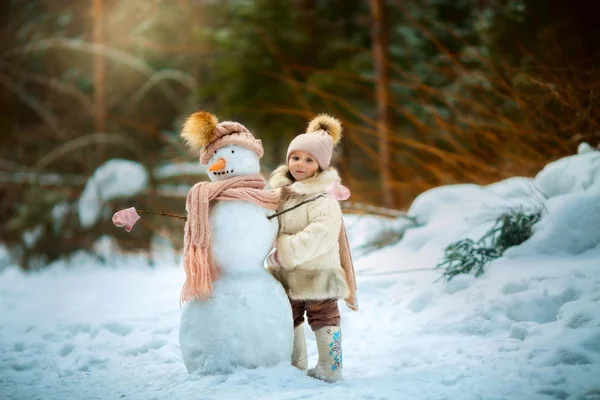 Petite fille avec bonhomme de neige — Photo