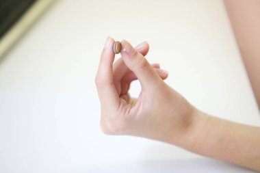 Bir kadının elinde çok küçük bir işitme cihazı