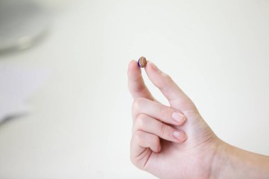 Bir kadının elinde çok küçük bir işitme cihazı