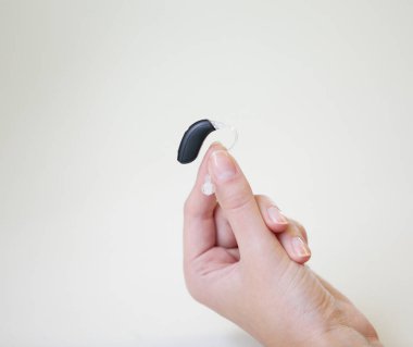Bir kadının elinde çok küçük bir işitme cihazı