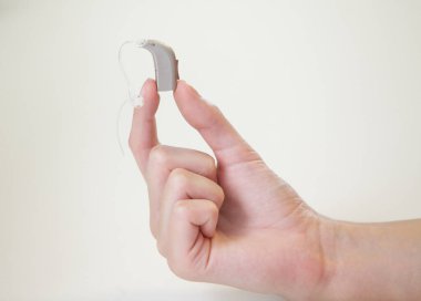 Bir kadının elinde çok küçük bir işitme cihazı