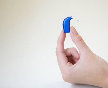 Bir kadının elinde çok küçük bir işitme cihazı