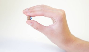 Bir kadının elinde çok küçük bir işitme cihazı