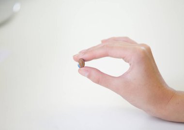 Bir kadının elinde çok küçük bir işitme cihazı