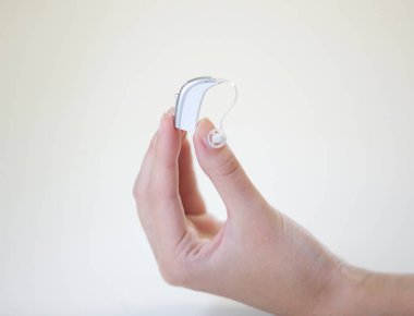 Bir kadının elinde çok küçük bir işitme cihazı