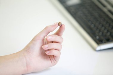 Bir kadının elinde çok küçük bir işitme cihazı