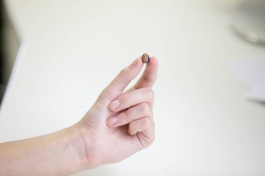 Bir kadının elinde çok küçük bir işitme cihazı