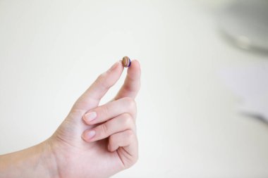 Bir kadının elinde çok küçük bir işitme cihazı