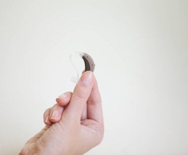 Bir kadının elinde çok küçük bir işitme cihazı