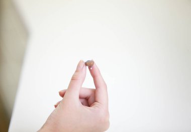 Bir kadının elinde çok küçük bir işitme cihazı